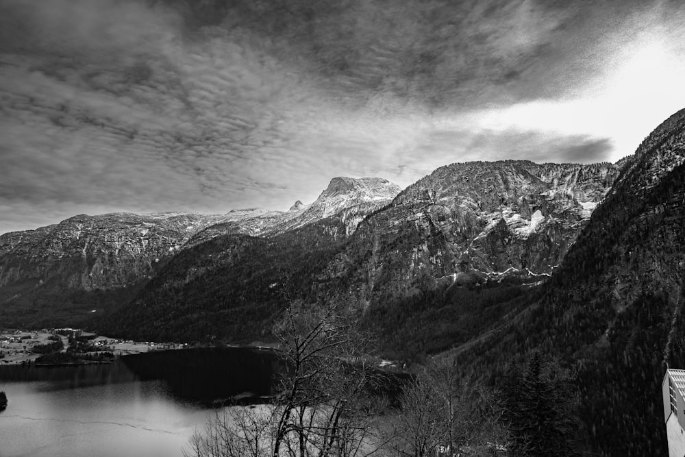 a black and white photo of mountains and a lake