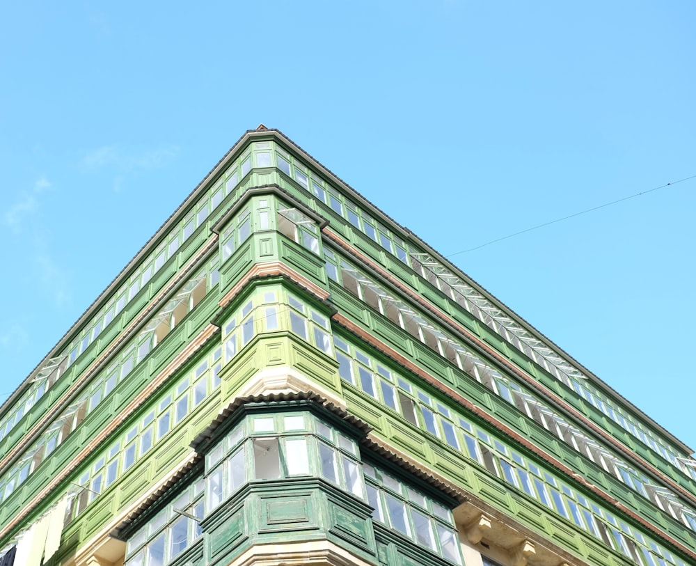 a very tall green building with lots of windows