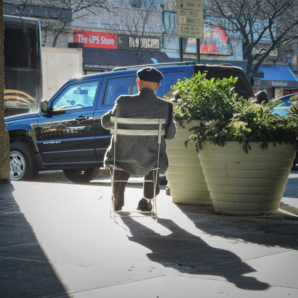 a man sitting in a chair on the sidewalk