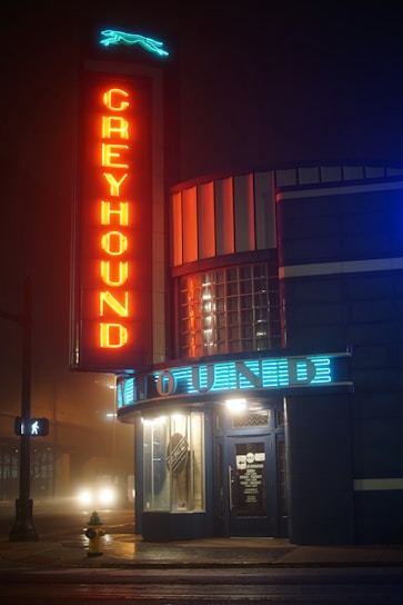 a building with a neon sign that reads greyhound
