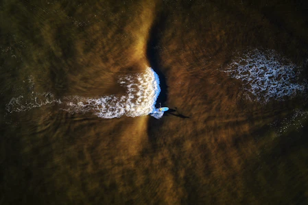 a person riding a wave on top of a surfboard