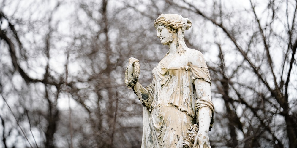 a statue of a woman holding a bird in her hand