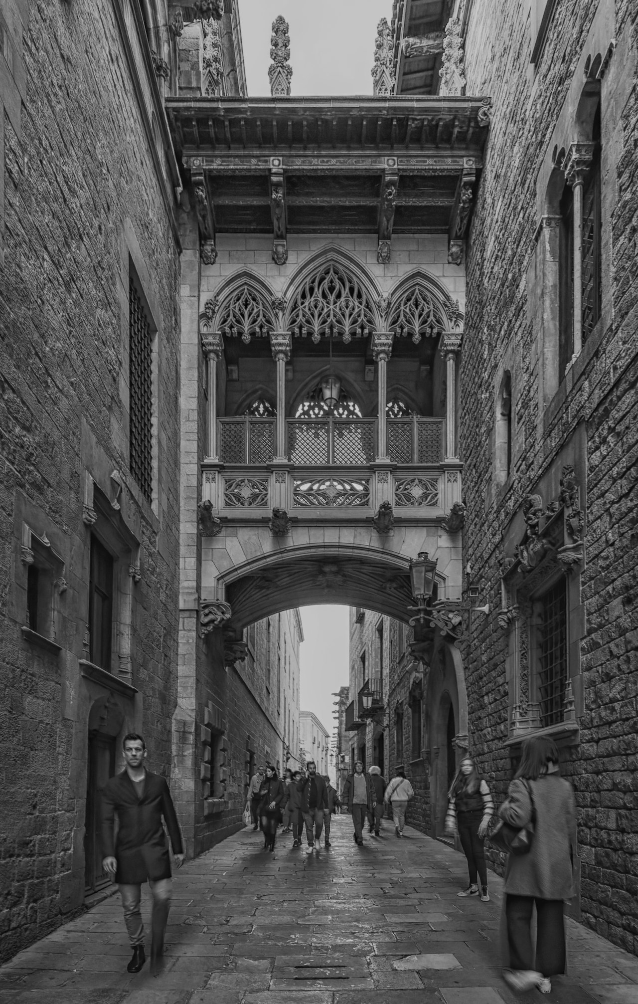 a black and white photo of people walking down a street