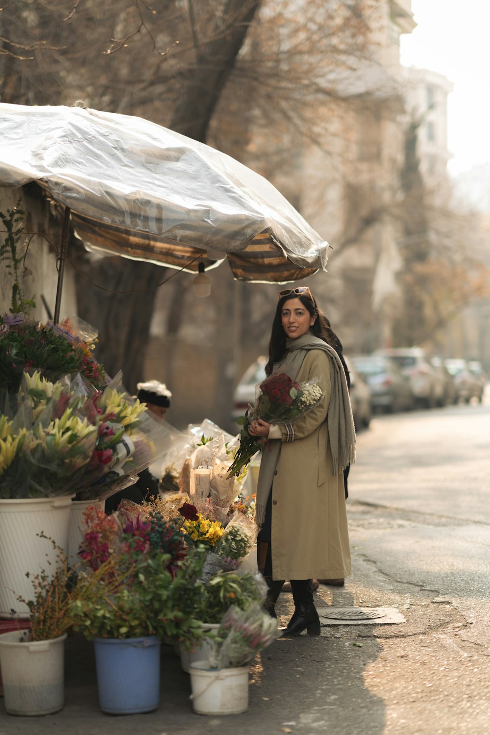 a woman standing next to a bunch of flowers