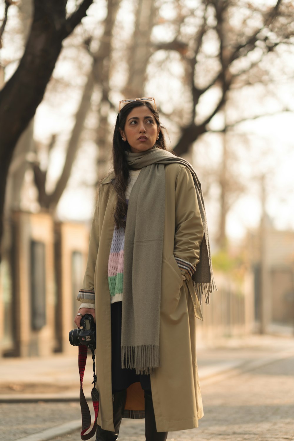 a woman standing on a sidewalk with a camera