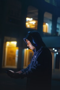 a man in a hoodie using a cell phone