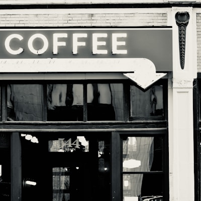 Close-up of a vintage sign hanging above a cozy coffee shop in Old City.