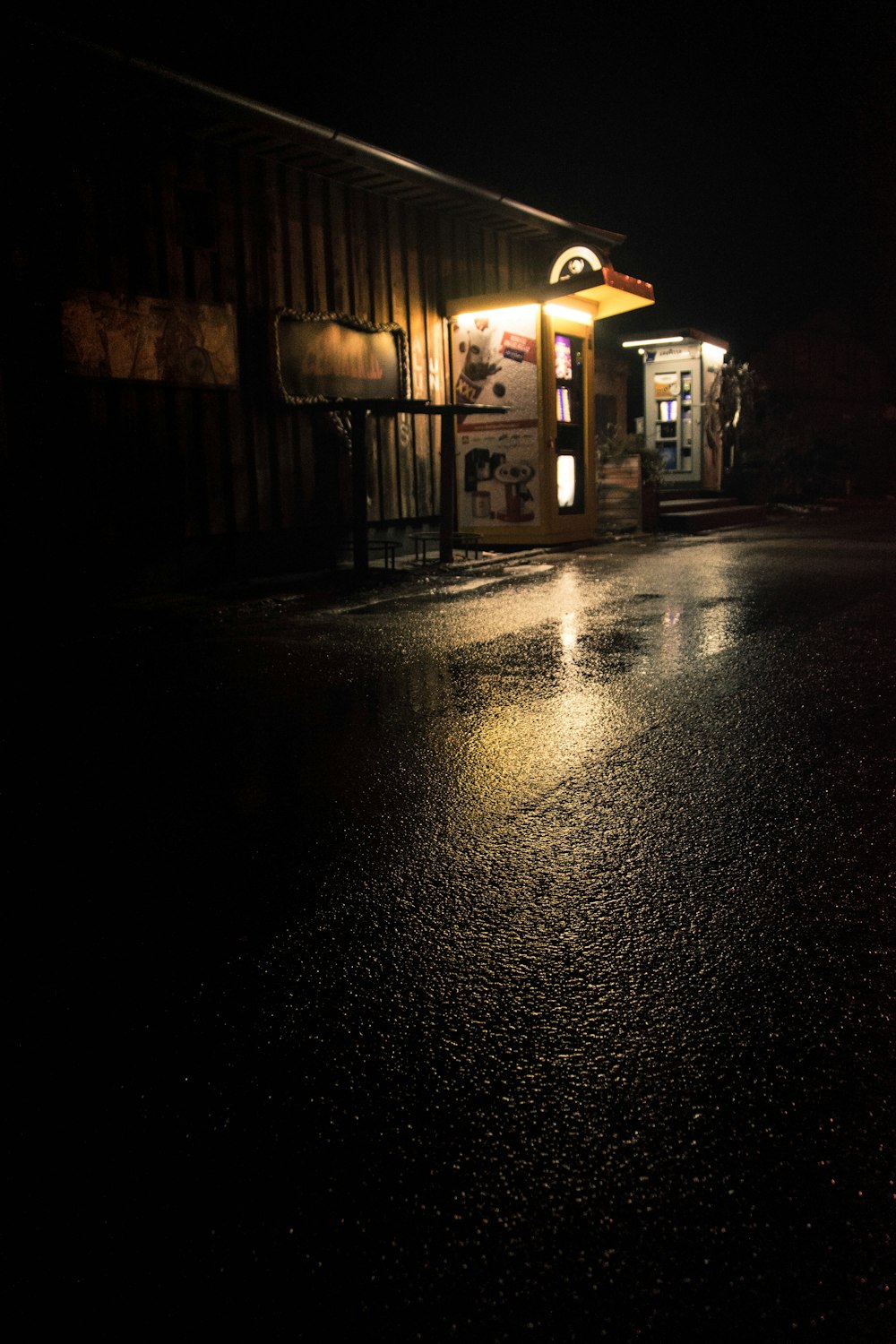 Eine dunkle Straße in der Nacht mit einer beleuchteten Ladenfront