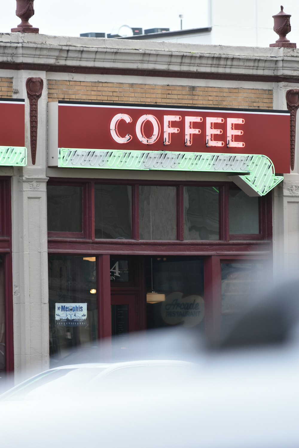 a car is parked in front of a coffee shop