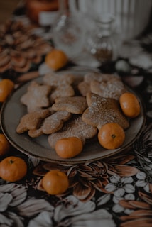 a plate of cookies and oranges on a table