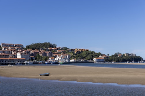 a small boat on the shore of a body of water