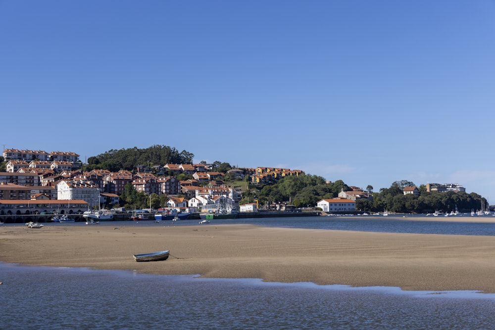 a small boat on the shore of a body of water