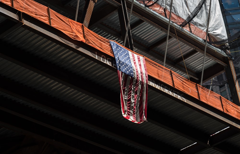 a red, white and blue american flag hanging from a building