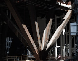 Close-up of hands measuring steel beams on a construction site.