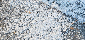 Surface of asphalt driveway with salt and water damage before repair