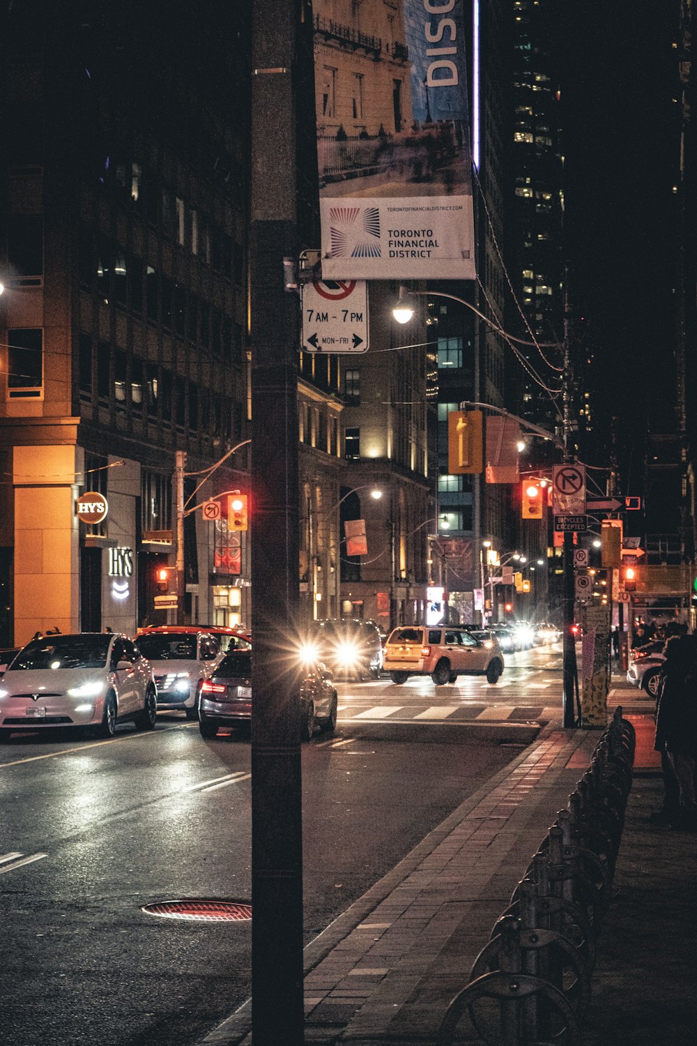 a busy city street at night with cars driving down it