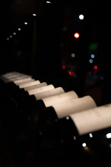 Elegant wine bottles arranged on a sleek black matte surface with soft golden lighting highlighting their labels.