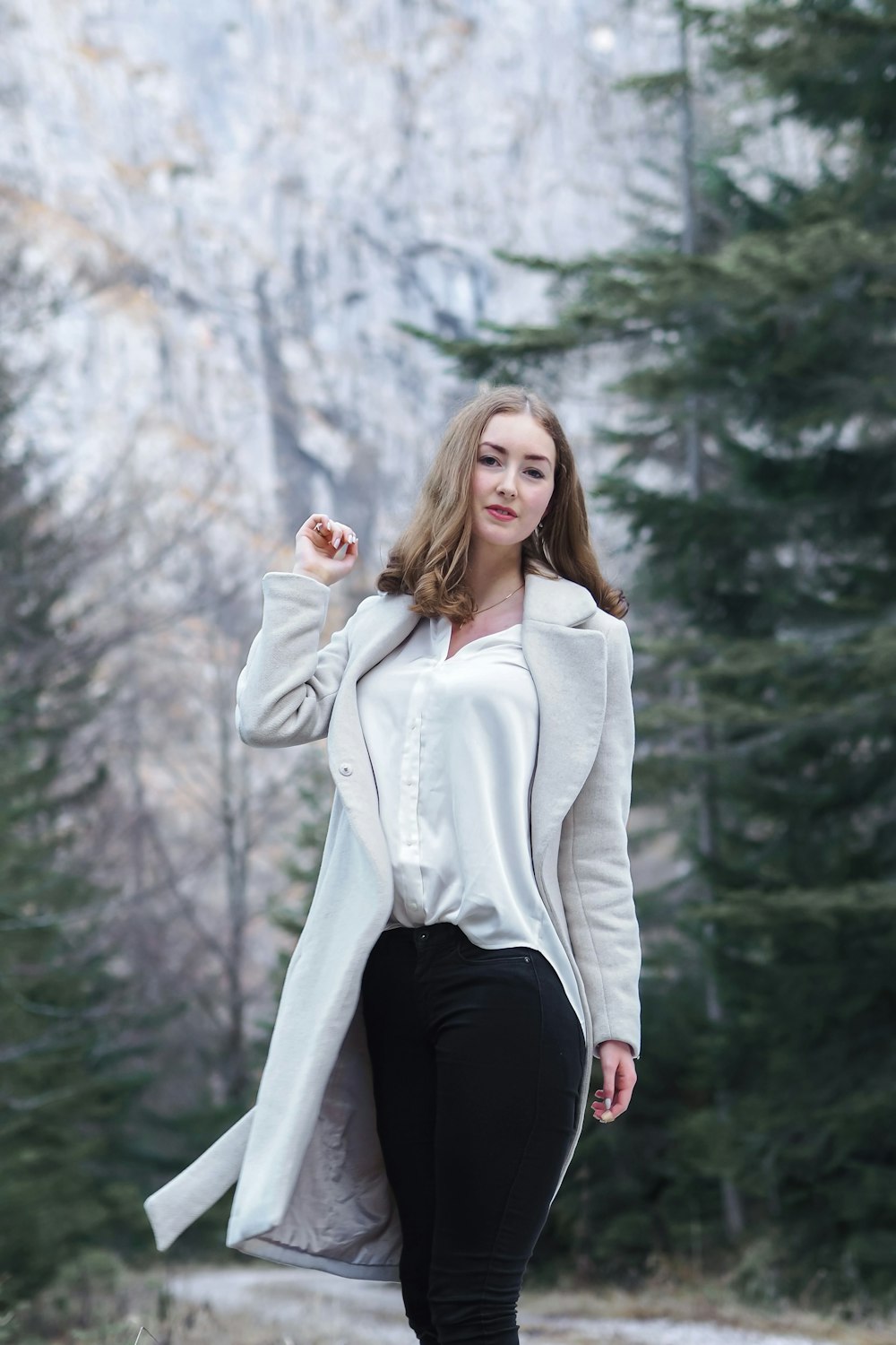 a woman in black pants and a white jacket