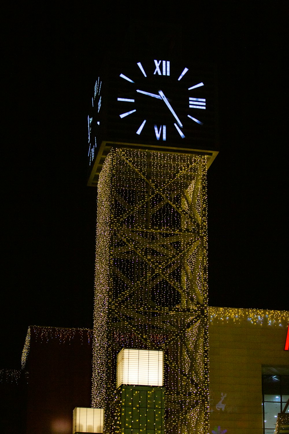 a large clock tower with lights on it's sides