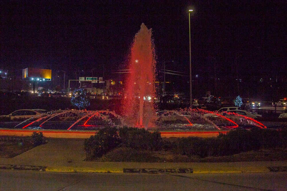 a large fountain is lit up at night