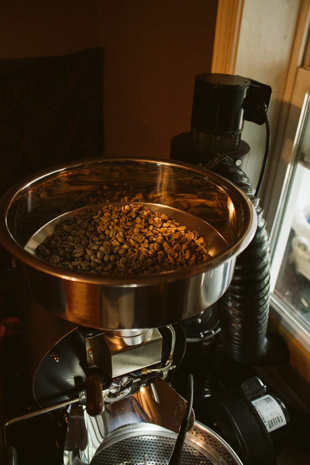 a coffee maker with a bowl full of coffee beans