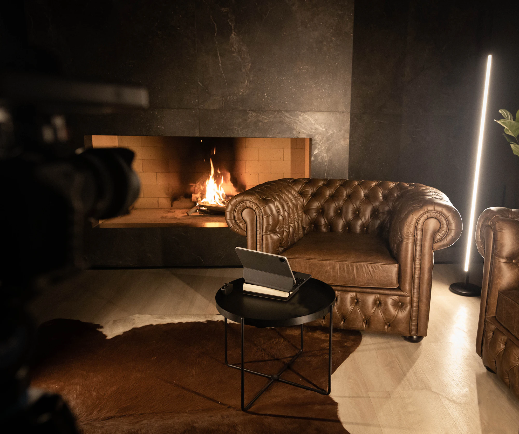 A leather armchair beside a lit fireplace