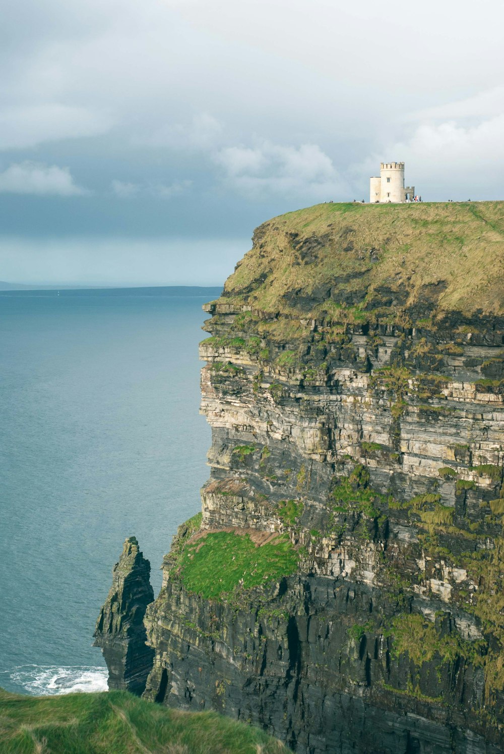 a lighthouse on a cliff overlooking the ocean