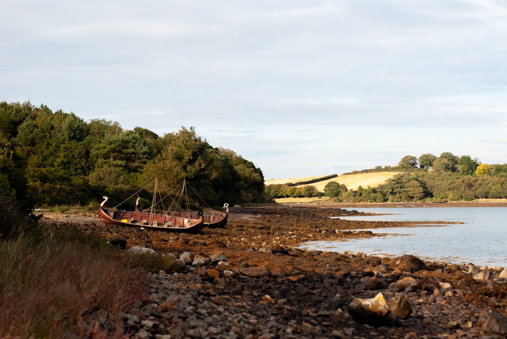 a boat sitting on top of a rocky shore