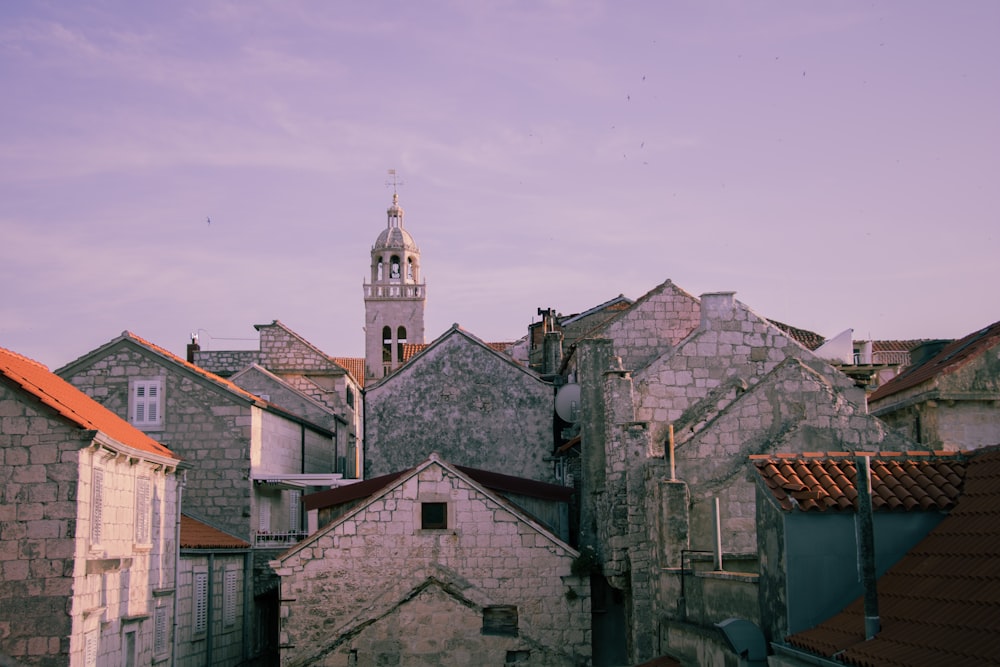 a view of some buildings with a clock tower in the background