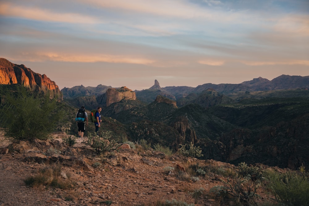 a couple of people that are standing on a hill