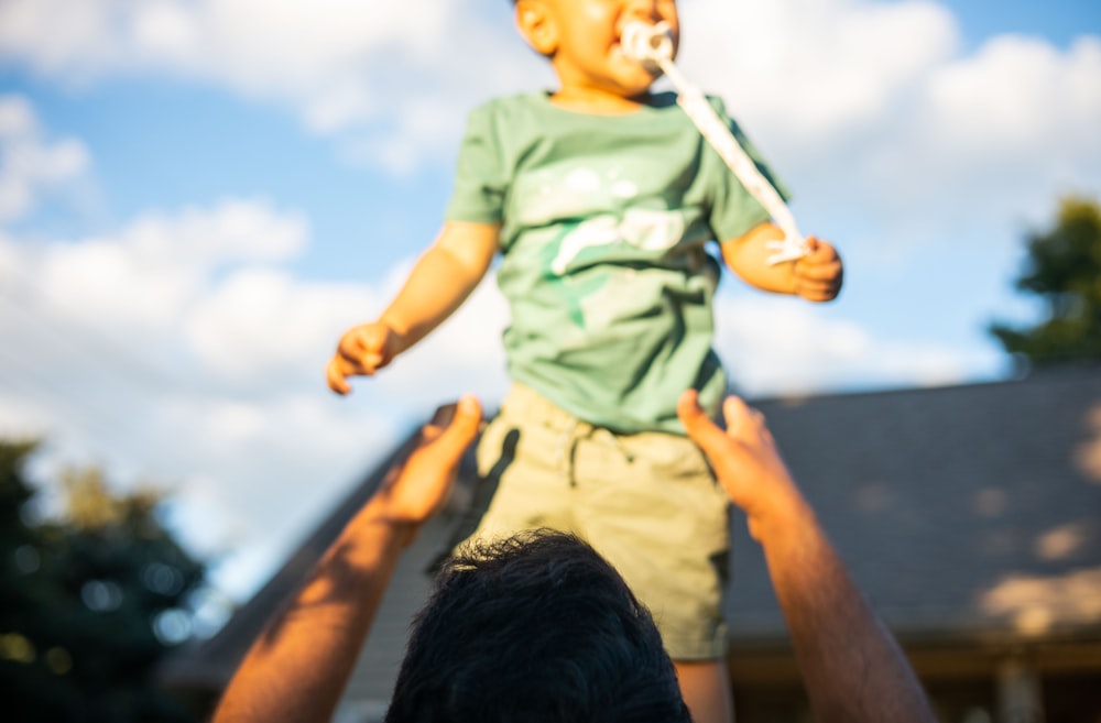 a man holding a small child on his shoulders