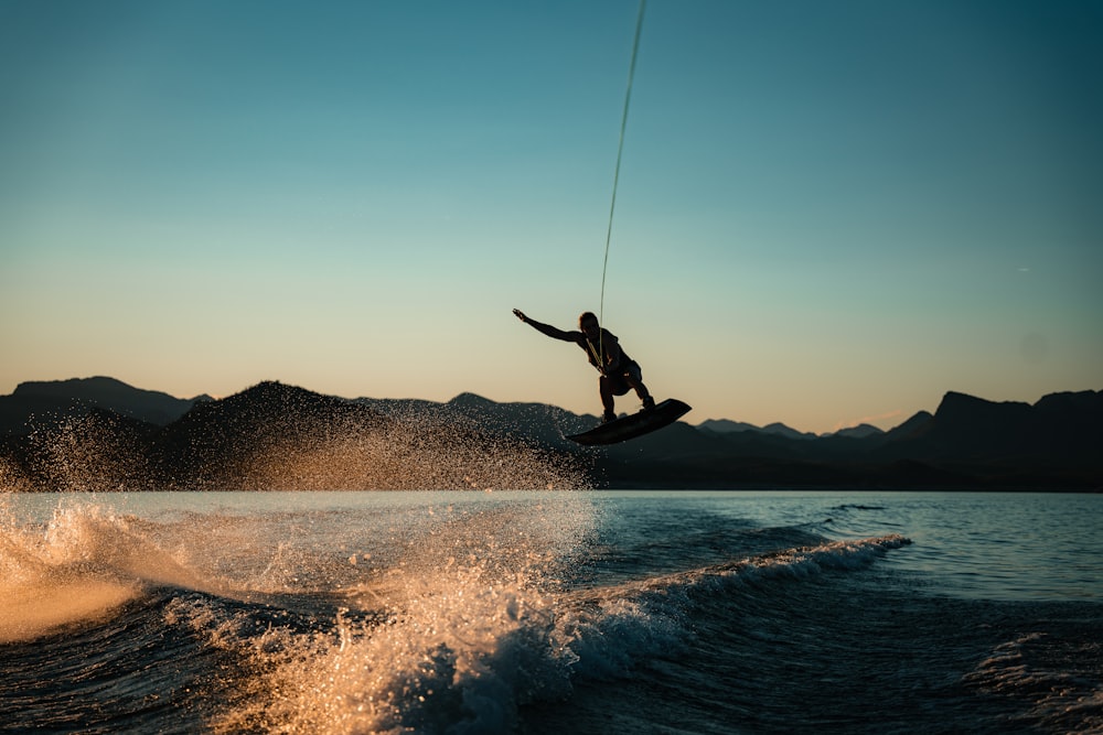 a person on a surfboard in the air above the water