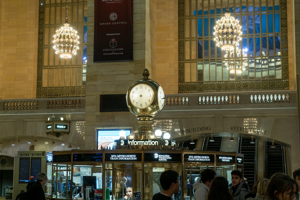 a group of people standing around a clock in a building