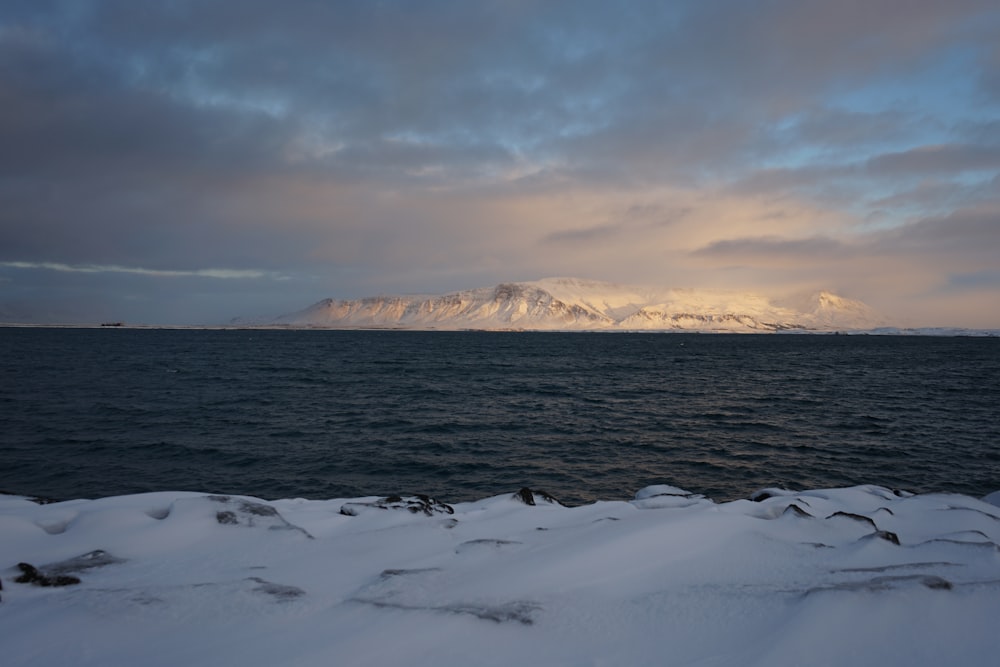 a large body of water sitting under a cloudy sky