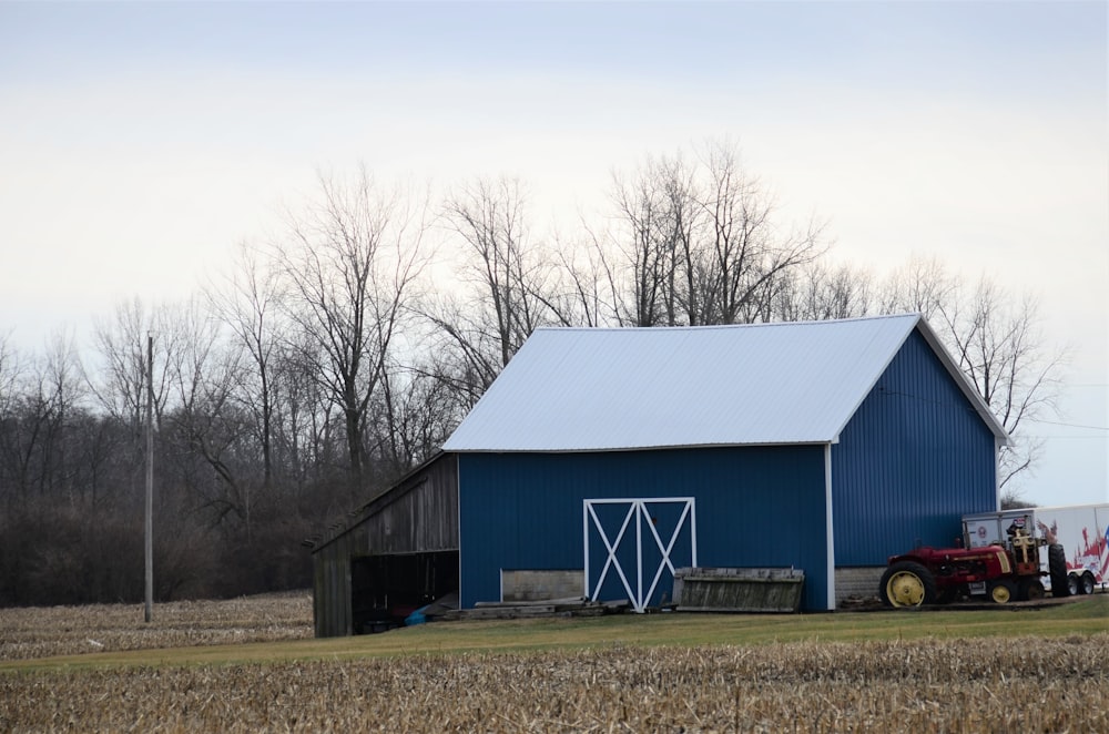 a tractor parked in front of a blue barn