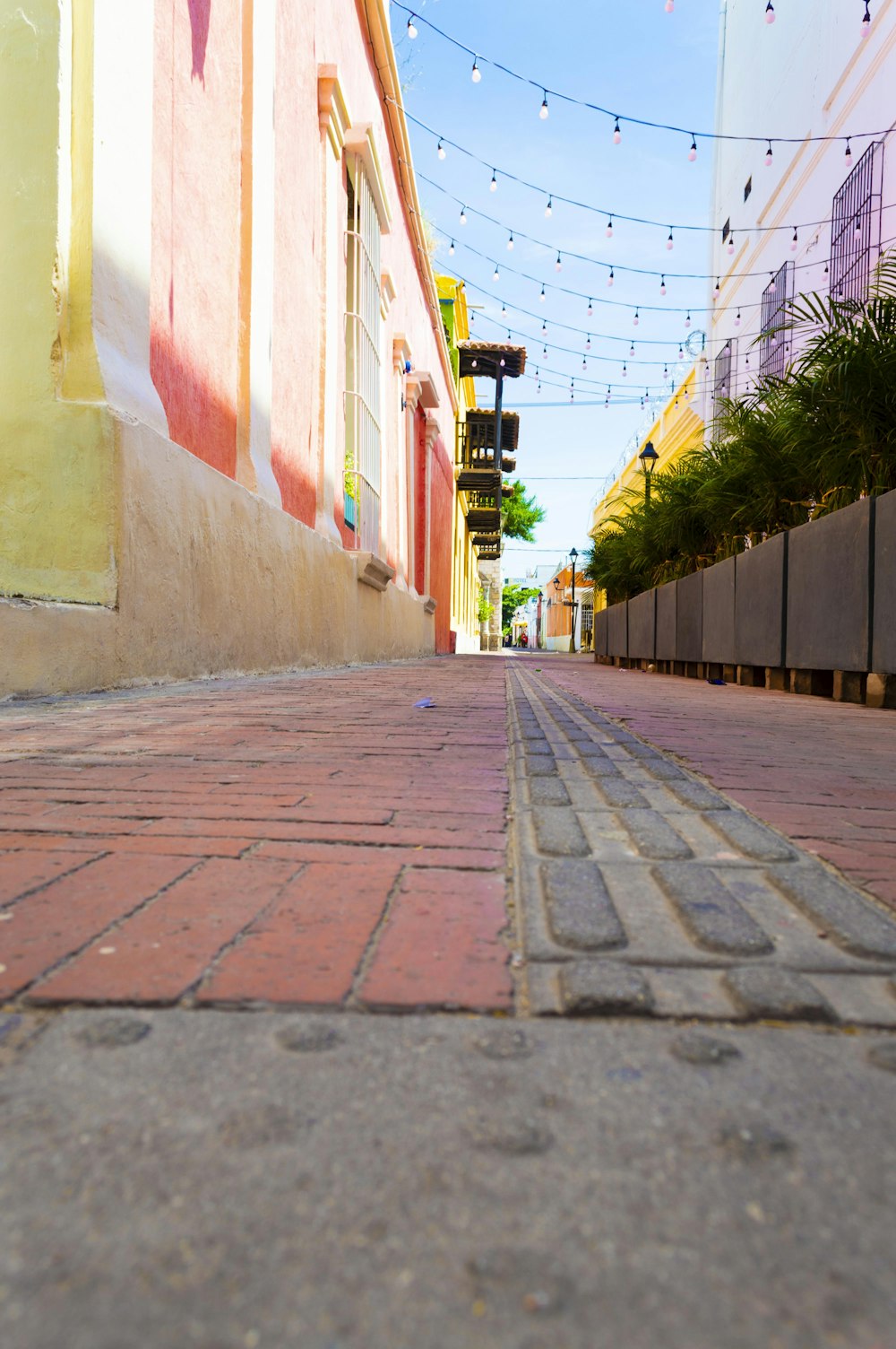 a red brick street with a traffic light on the side of it