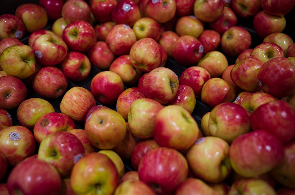 a pile of red and yellow apples sitting on top of each other