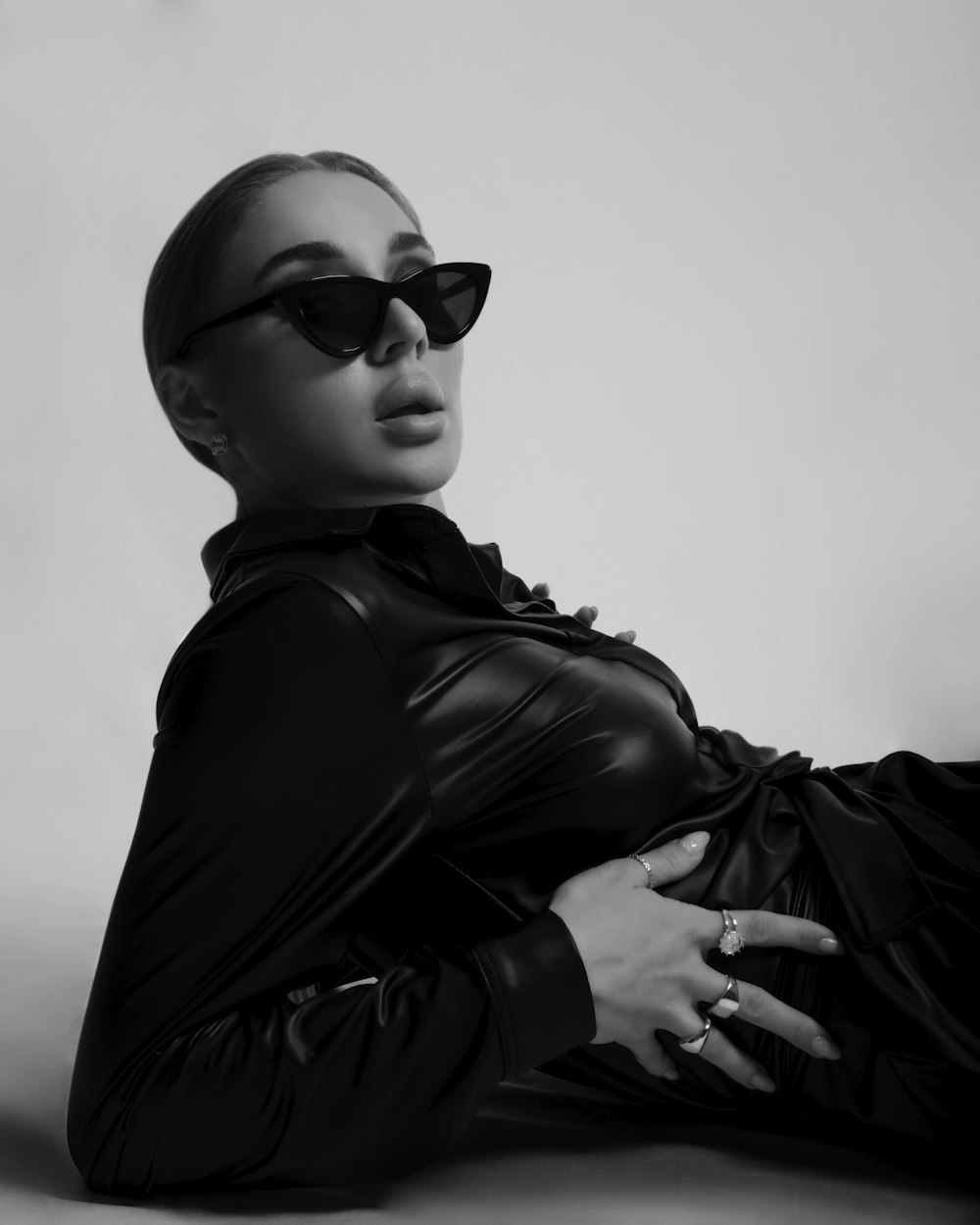 a woman in a black leather outfit and sunglasses