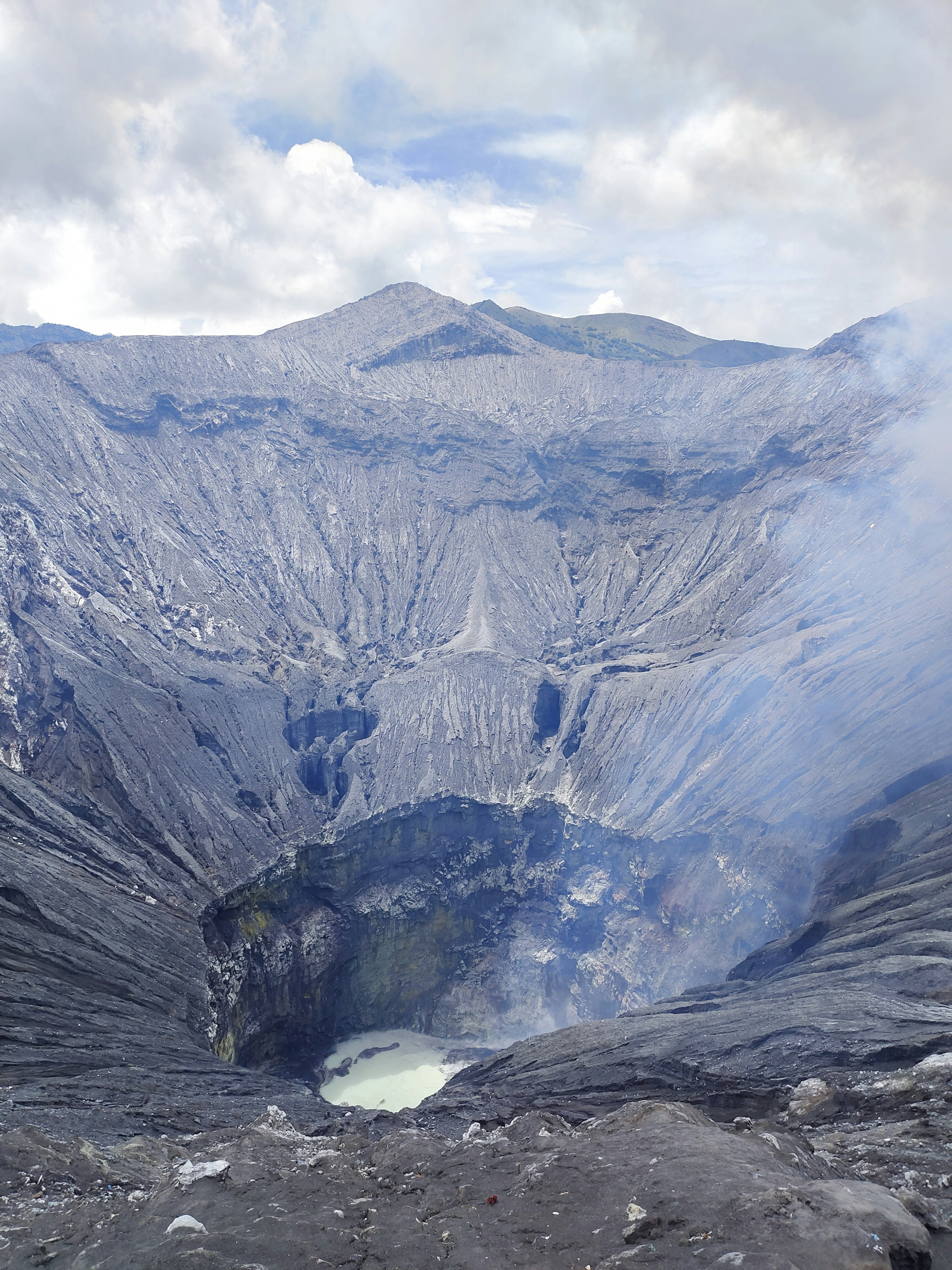 Steaming volcanic boiling lake in Dominica with sulphurous mist and rocky crater edge