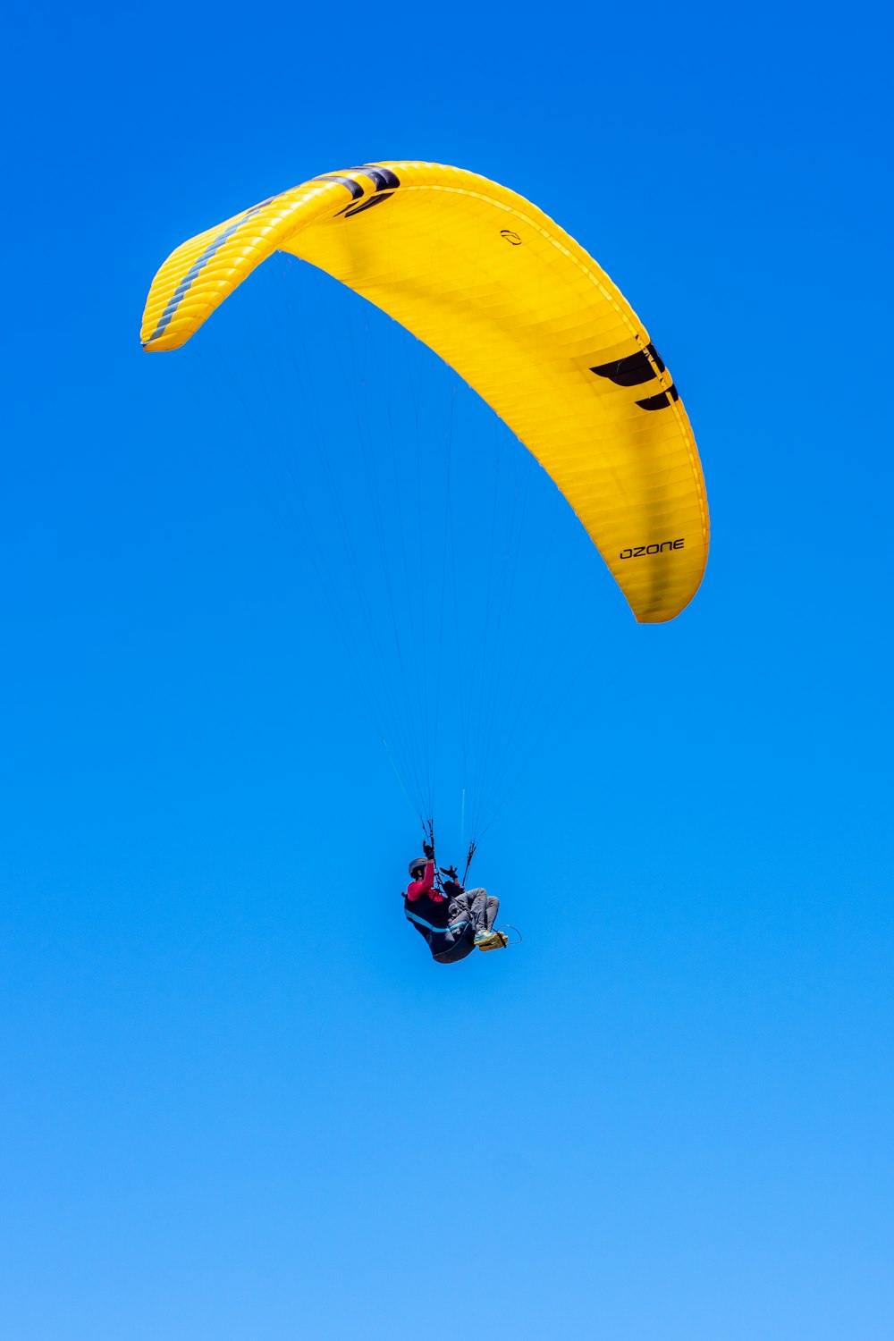 a person is parasailing in the blue sky