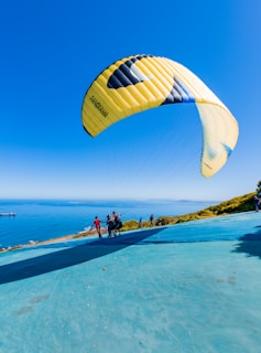 Paramotor pilot preparing the banner before takeoff on a sunny beach.