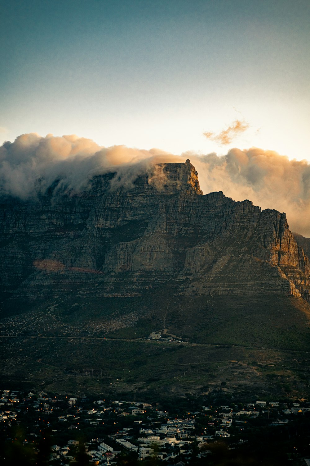 une vue d’une montagne avec des nuages qui roulent dessus