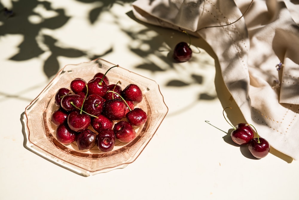 a bowl of cherries sitting on a table