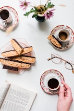 a person is holding a cup of coffee and some cookies