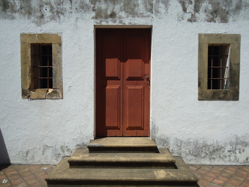 a red door is open on a white building