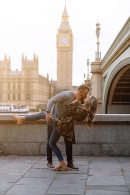 photography poses for couples,how to photograph london lovers; a man and woman kissing in front of a clock tower