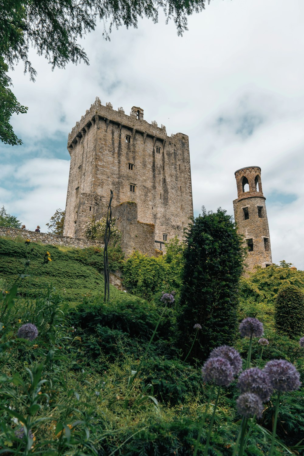 a tall tower sitting on top of a lush green hillside