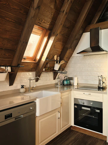 A warm, inviting kitchen showroom featuring a modern oak and white kitchen set with natural light and cozy accents.