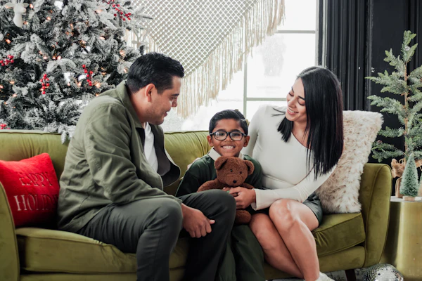Parents and their son on a green sofa with holiday decor