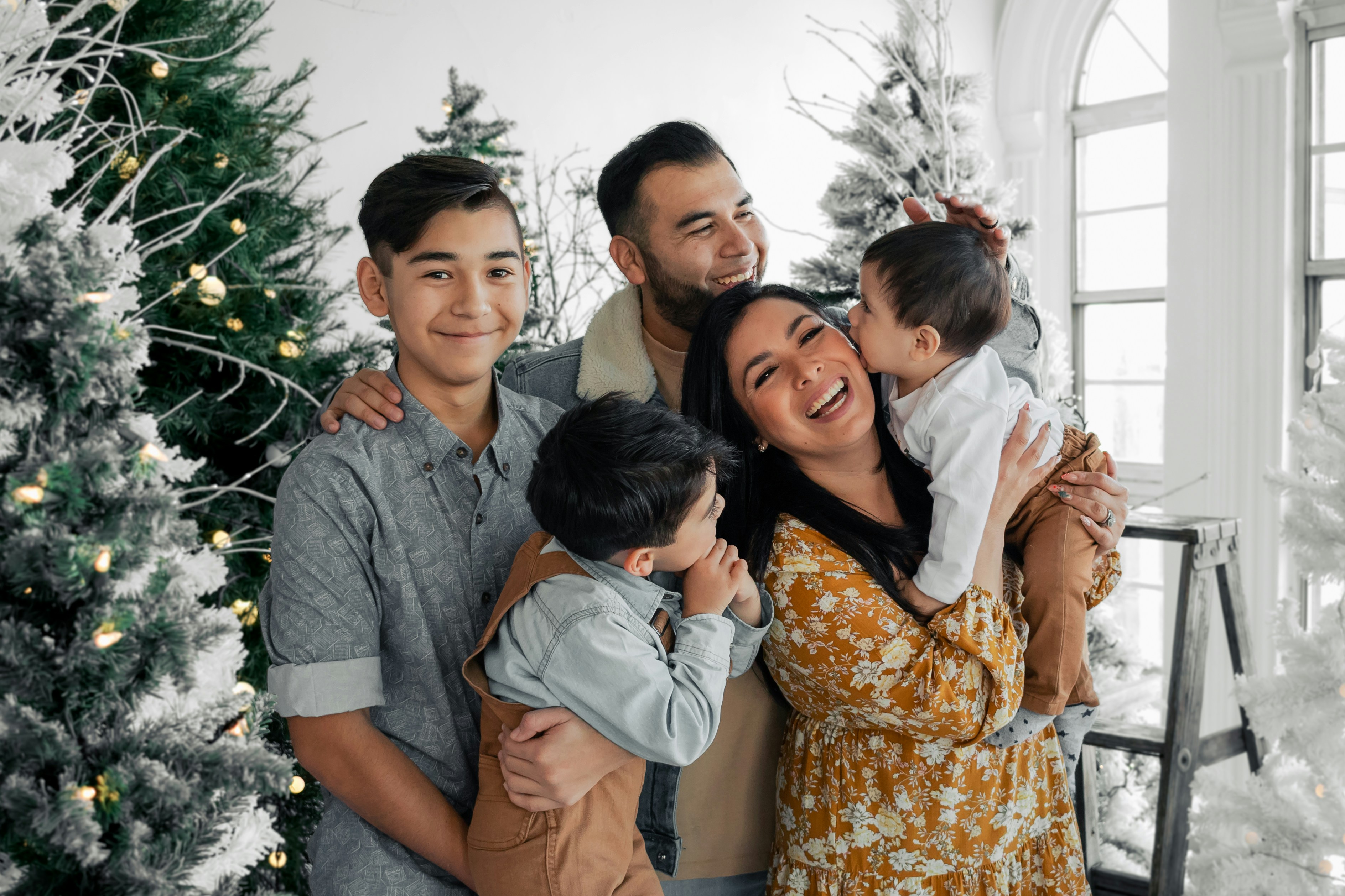 A group of people standing in front of a christmas tree photo – Free ...